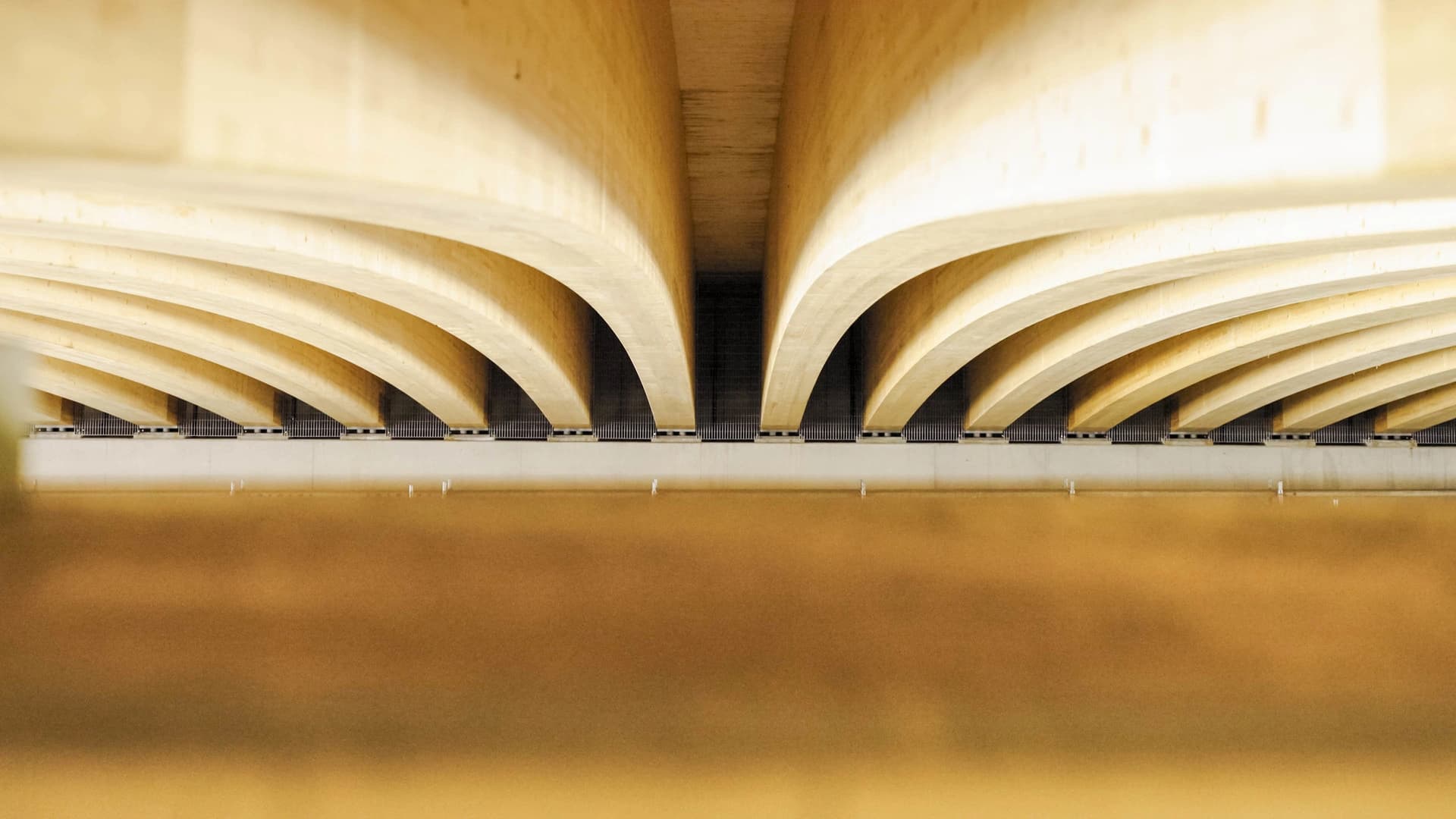 Vue en perspective sous un pont en bois, montrant d'imposantes poutres en lamellé-collé.